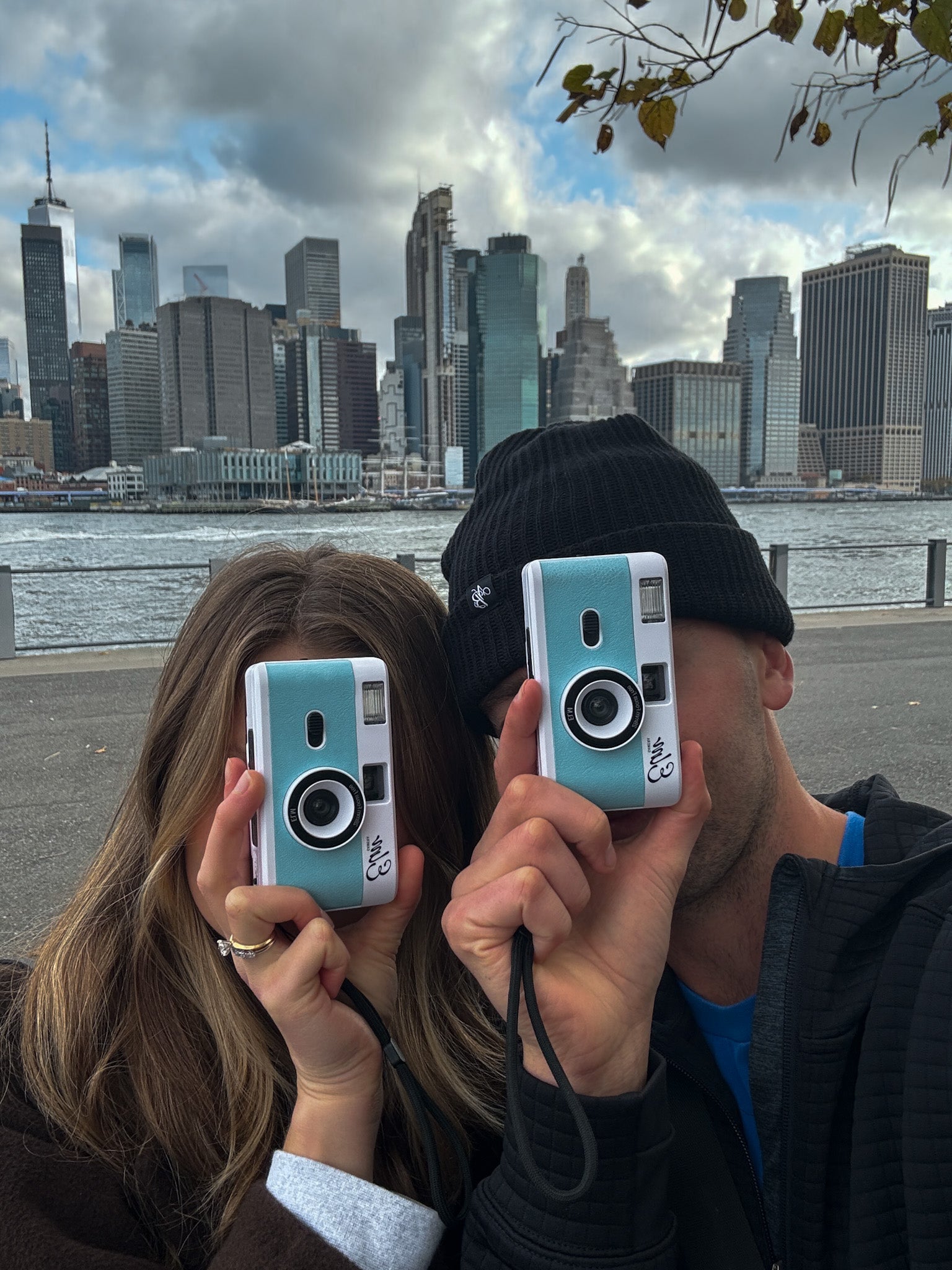 ELM founders Lawson and Emma holding film cameras in New York City